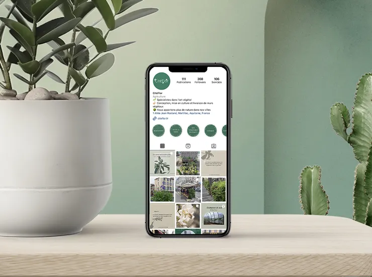 Un pot de plante et un portable sur une table avec l'instagram de Citéflor ouvert.