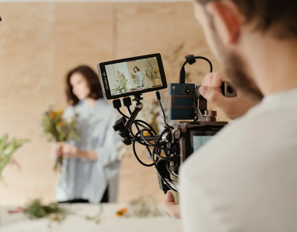 Caméraman qui filme une femme tenant un bouquet de fleurs